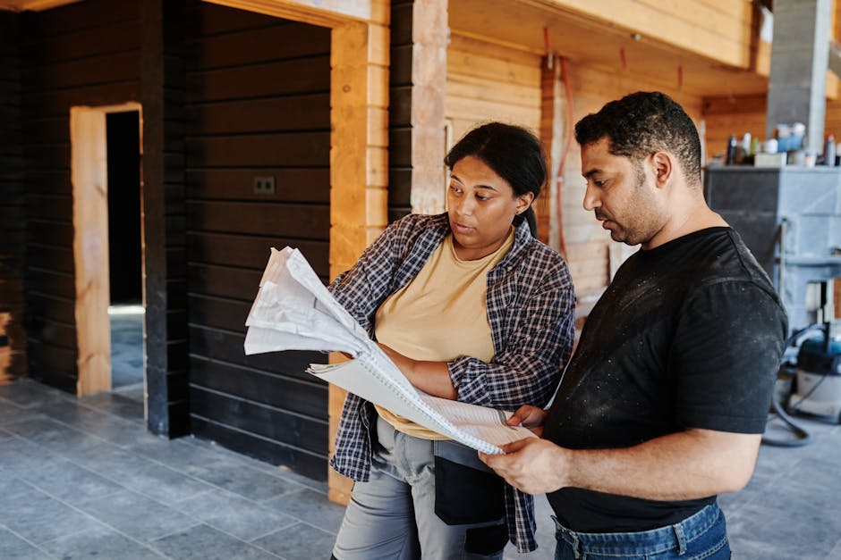 Contractor reviewing kitchen blueprints on site